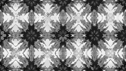 Intricate grayscale pattern featuring symmetrical floral and leaf like motifs