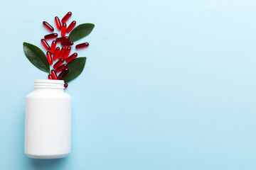 different drugs and health supplement pills poured from a medicine bottle health care and medical top view on colored background