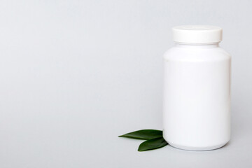 supplement pills with medicine bottle health care and medical top view. Vitamin tablets. Top view mockup bottle for pills and vitamins with green leaves, natural organic bio supplement, copy space