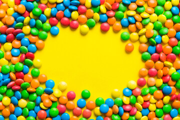 Mixed collection of colorful candy, on colored background. Flat lay, top view. frame of colorful chocolate coated candy
