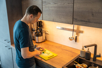 Man slicing mushrooms on a kitchen counter. Healthy food preparation.
