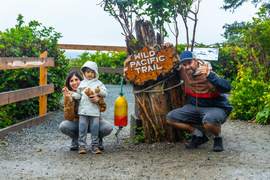 Family posing at wild pacific trail sign in ucluelet