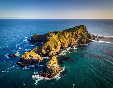 Aerial shot of rocky island and ocean with lighthouse - Powered by Adobe