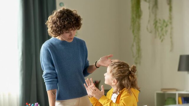 Adult woman talking to young son having calm argument while child doing homework in bedroom, AI generated footage