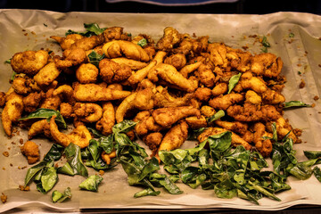 Authentic Thai or Indian street snack &mdash; crispy fried bites with fresh curry leaves, ready to eat, perfect for travel content or culinary storytelling.