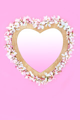 Apple blossom romantic heart shape spring wreath, wooden frame on pink, gradient fill. Symbol of love for Mothers Day, Beltane, Valentines, birthday, wedding.