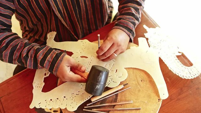 Artisan carving a traditional Javanese shadow puppet