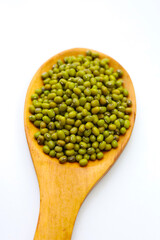 Green mung beans on wooden spoon.