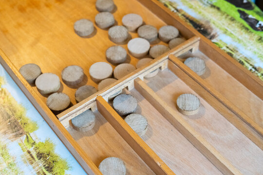 Dutch shuffleboard game, sjoelbak, on table with pucks in trays and on playing surface