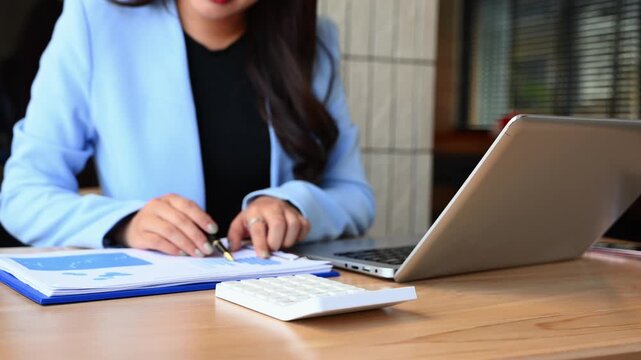 Women counting coins on calculator taking from the piggy bank. hand holding pen working on desk about cost at office.