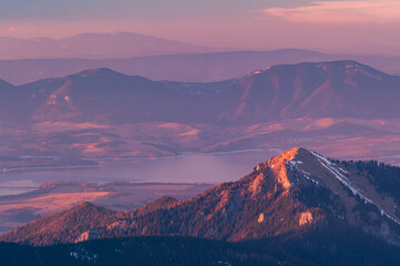Aerial view of the sun kissing the peaks of the Low Tatras mountains, casting a warm glow over the landscape, Derese, Zilina Region, Slovakia.