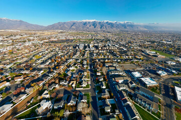 Aerial view of a symmetrical layout of residential houses and streets contrasting with the distant snow-capped mountains, Layton, Utah, United States.