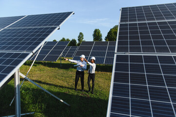 Engineers discussing solar energy field with panels