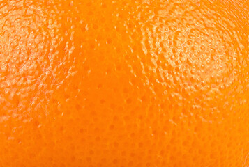 Ripe orange peel as background. Texture of orange skin, surface details close up. Citrus fruit.
