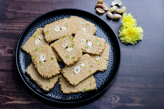 Til gajak, a traditional Indian winter sweet made with sesame seeds, jaggery, ghee, and dryfruits. Crunchy til chikki festive treat for Makar Sankranti. Tilgul. sesame candy. Copy Space. Winter food.