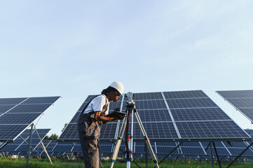 Woman engineer surveying solar panel installation field