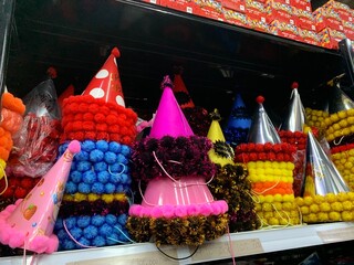 Colorful decorative ornaments knick knacks for birthday celebrations or religious celebration decorations sold in shops. The items include shiny, spherical red, green, gold, pink, and silver.