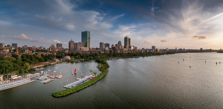 Aerial view of the Charles River reflecting the skyline with the iconic Prudential Tower and John Hancock Tower under a sky brushed with sunset hues, Boston, Massachusetts, United States.