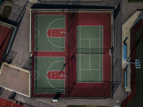 Aerial view of geometric harmony in sports courts, with contrasting red and green hues creating a vibrant tableau of recreation, Boston, Massachusetts, United States.