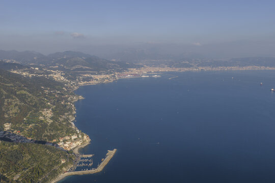 Aerial view of the rugged coastline meeting the serene waters, with the village nestled amongst the greenery, Erchie, Amalfi Coast, Campania, Italy.