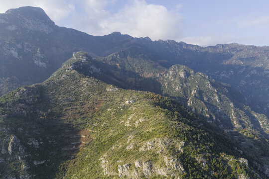 Aerial view of rugged, verdant mountains rise majestically, kissed by the soft glow of sunlight, creating a tapestry of light and shadow, Erchie, Amalfi Coast, Campania, Italy.