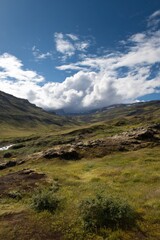Fototapeta premium Scenic landscape with lush green hills and dramatic cloudy sky
