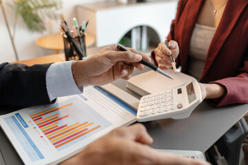 A collaborative startup meeting showing professionals reviewing financial charts and discussing strategic ideas in a modern office setting.
