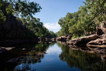 Obraz premium Tranquil forest river with rock formations and clear blue sky