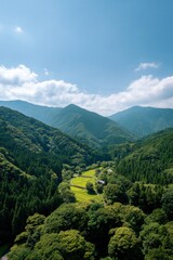 Fototapeta premium Scenic view of lush green valley and mountains under a clear sky