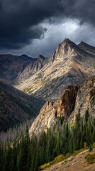Dramatic Rocky Mountains Under Stormy Clouds with Sunlight.