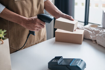 SME owner uses barcode scan on small box for ecommerce logistics