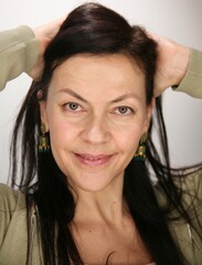 Portrait of attractive middle aged brunette woman 52 years old with nude make-up and natural hair styling