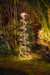 Abstract Christmas tree made from garland lights in the garden
