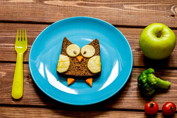 breakfast for child on blue plate at wooden background