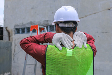 Fototapeta premium Closeup of Construction Worker Holding Injured Wrist, Wearing Gloves and Safety Vest, Near Ladder