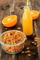 flakes in bowl with orange on dark wooden background