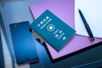 空港の椅子に置かれた携帯電話と台湾のパスポート