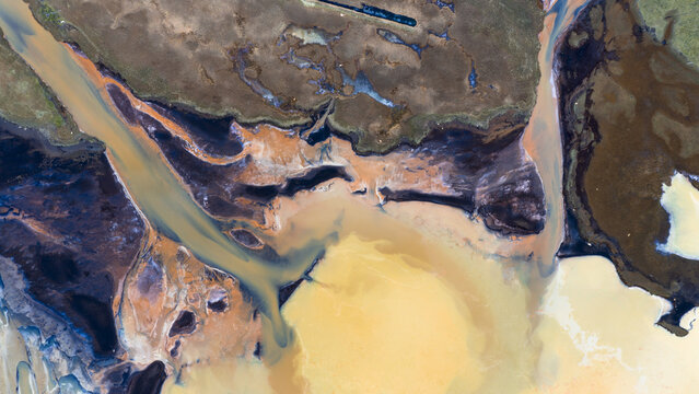 Aerial view of the delta's intricate waterways weaving through the landscape, a tapestry of ochre and azure hues, Iceland.