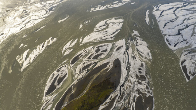 Aerial view of glacial river patterns creating a stunning mosaic of textures and tones across the landscape, Iceland, Iceland.