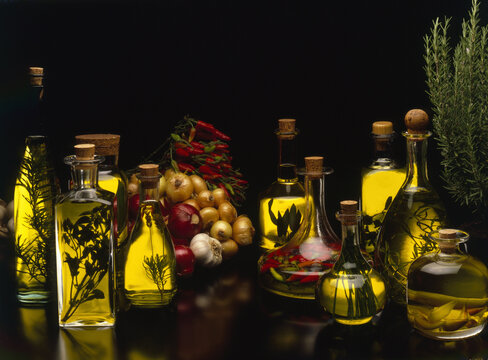 Bodegon aceites de oliva en botellas de cristal y fondo negro