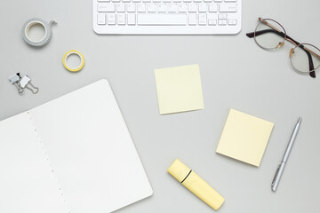 Organized workspace with stationery, keyboard, glasses and notebook creating productive atmosphere