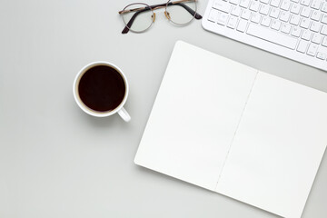 Cozy workspace with coffee cup, keyboard, glasses creating focused morning atmosphere