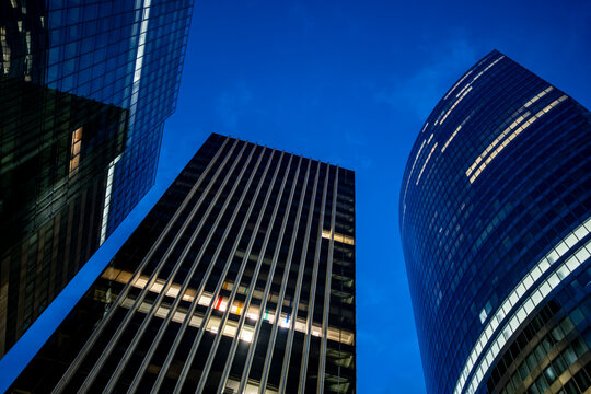 Night view of corporate skyscrapers architecture in La Defense Paris highlighting modern finance business offices in an illuminated urban district