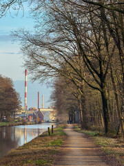 Obraz premium Pathway by the canal with industrial backdrop
