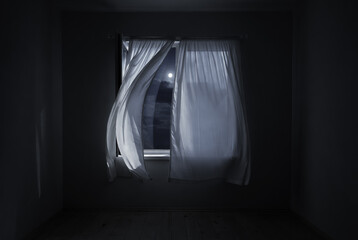 The wind from the window flutters the curtains in the old house in the moonlight.