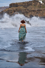 Woman walking into ocean waves