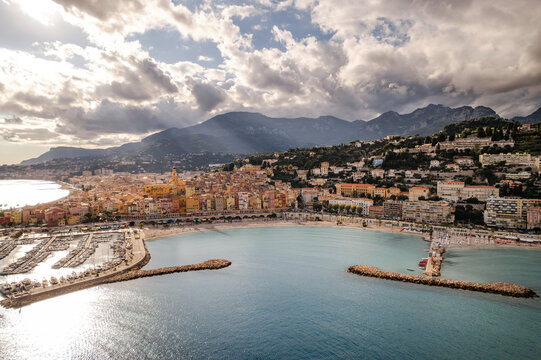 Aerial view of the vibrant, sun-kissed coastline where terracotta rooftops meet the azure Mediterranean, framed by the dramatic backdrop of the mountains, Menton, Provence-Alpes-Cote d'Azur, France.