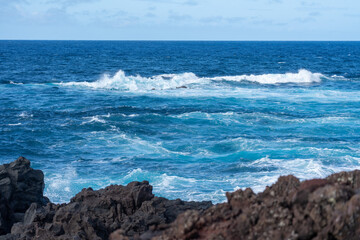 Atlantic waves crash against the dark volcanic rocks of an island coastline I
