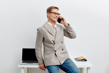 smiling man talking phone casual wear glasses sit table laptop notebook communicate remote work digital nomad concept modern technology