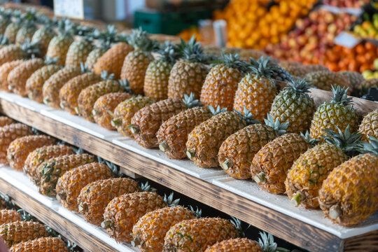 A vibrant display of unique S&atilde;o Miguel pineapples stacked on wooden crates at a local market in Ponta Delgada,  Azores